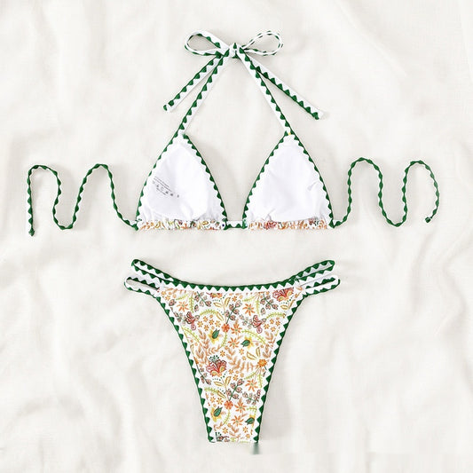 White halter bikini with green rickrack trim and a vibrant floral and bird print, featuring a triangle top and high-cut bottom. - Image 2
