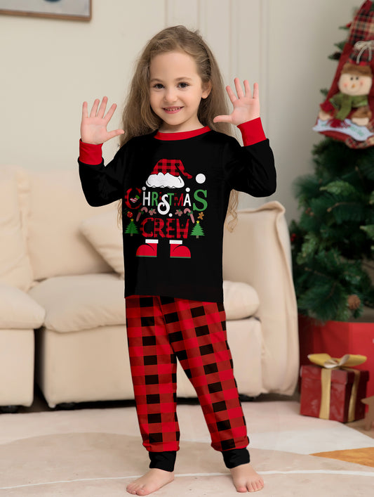Man wearing black and red plaid Christmas pajamas with a Santa graphic top and matching pants. - Image 2