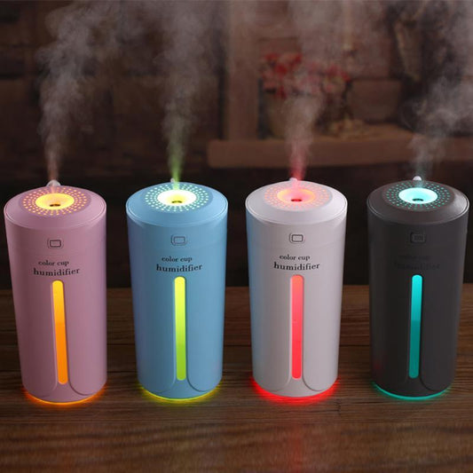 White mini USB ultrasonic humidifier with a green LED light strip, emitting mist, on a white surface. - Image 2