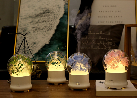 White aromatherapy machine with a clear dome top, featuring blue preserved flowers and an aqua glow. Includes 'LIGHT' and 'MIST' controls. - Image 2