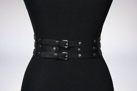 Women's black leather waist belt with three layers, silver-tone metal O-rings, and rivets on a black mannequin. - Image 2