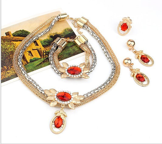 Bridal four-piece jewelry set with gold and silver-tone necklace, earrings, bracelet, and ring, featuring red crystal flowers. - Image 2