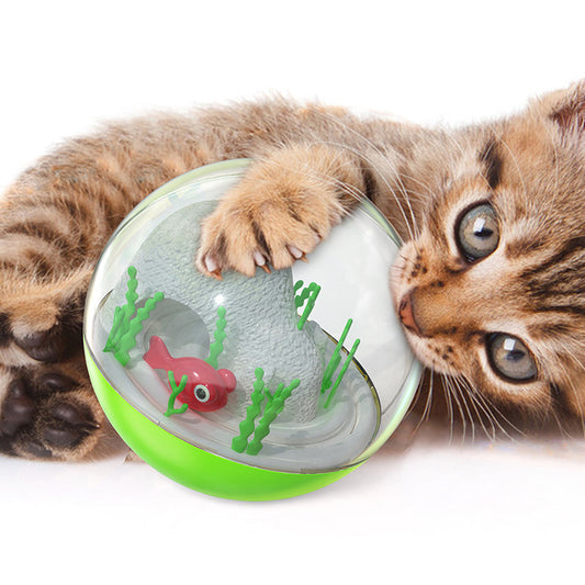 Clear and teal cat toy tumbler with a red fish and green seaweed inside, observed by a curious grey cat. - Image 2