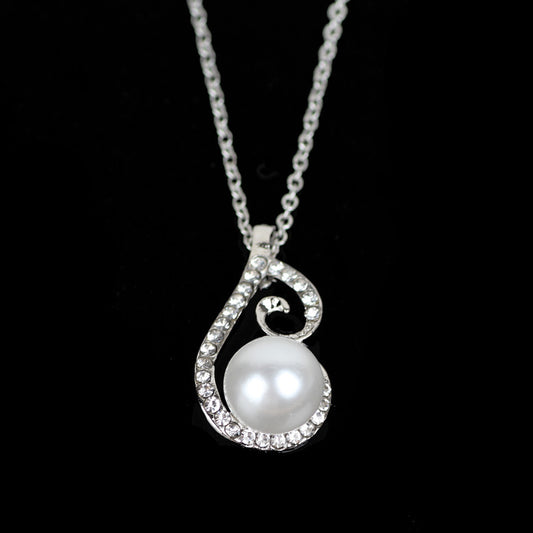 Silver-tone rhinestone and faux pearl drop necklace and matching earrings jewelry set on a black background. - Image 2