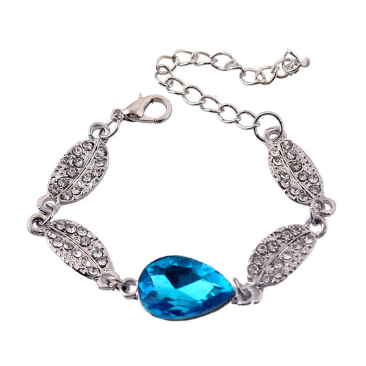 Silver-tone jewelry set with teardrop blue gemstones and clear rhinestones, including a necklace, bracelet, and earrings. - Image 2