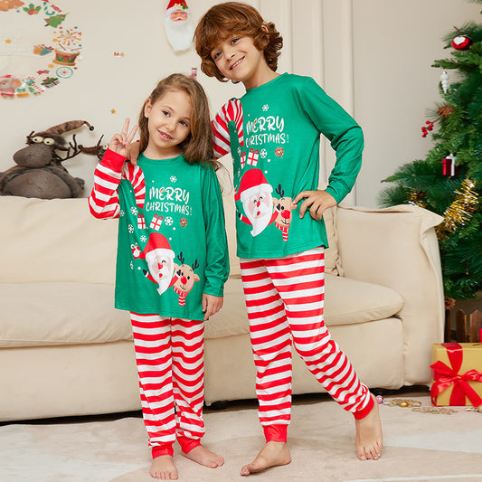 Family of four wearing matching green Christmas pajamas with Santa, reindeer, and red and white striped pants. - Image 2