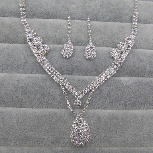 Sparkling silver-toned bridal necklace and matching drop earrings set with clear rhinestones. The necklace features a V-shape and a teardrop pendant, while the - Image 2