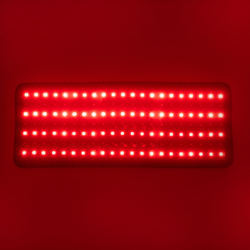 Two red light therapy wristbands with multiple bright LED lights and black adjustable straps, emitting a red glow. - Image 2