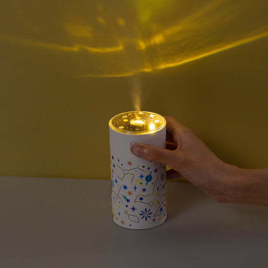 Dark green cylindrical humidifier with a clear top, featuring a colorful celestial pattern of stars, planets, and constellations. - Image 2