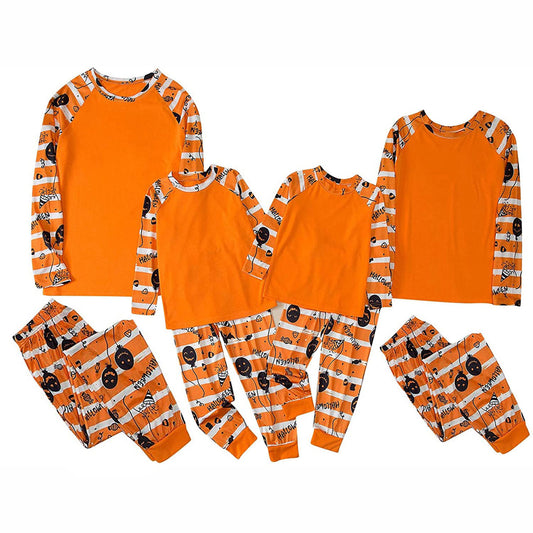 Family of four wearing matching orange and white striped Halloween pajamas with pumpkin and bat prints. - Image 2