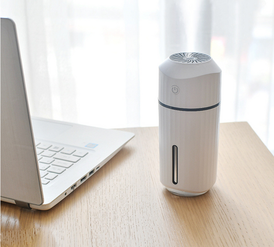 Pink columnar mini car humidifier with a power button and a clear water level indicator on a white background. - Image 2