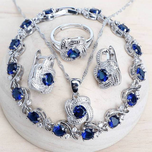 Blue zirconia jewelry set with silver-toned necklace, bracelet, ring, and earrings, featuring swirling designs. - Image 2