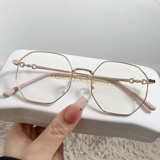 Rose gold frameless polygon anti-blue light glasses with clear lenses, held by a hand with pink nails. - Image 2