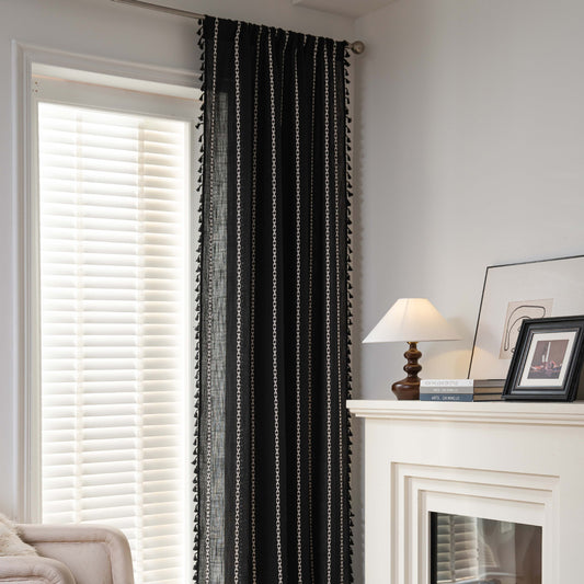 Black polyester curtain with white jacquard multi-line pattern and black tassels, draped over a white chair. - Image 2