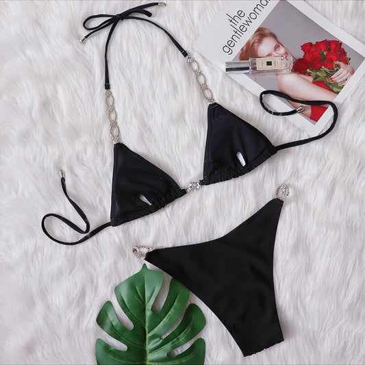 Black two-piece bikini with rhinestone chain halter straps and connectors, laid flat on white faux fur. - Image 2