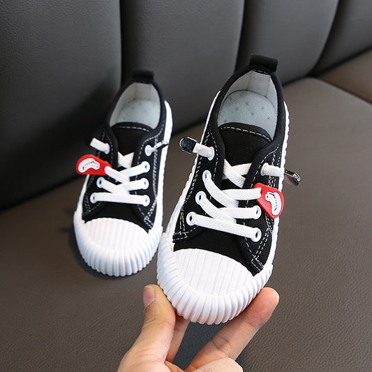 Pair of black canvas children's shoes with white laces and white rubber toe cap and sole. - Image 2