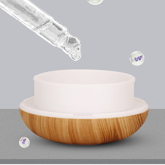 Teardrop-shaped aromatherapy humidifier with light wood grain finish, emitting mist and glowing with purple LED light. - Image 2