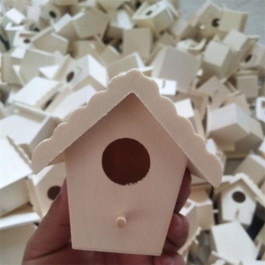 Unfinished wooden birdhouse with a circular entrance hole and a small perch, held by a hand. - Image 8