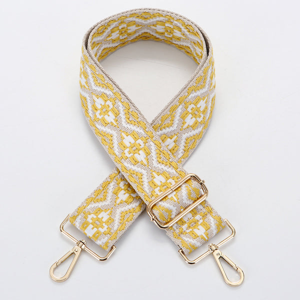 Yellow and white ethnic style patterned canvas bag strap with gold-toned adjustable buckle and swivel snap hooks.