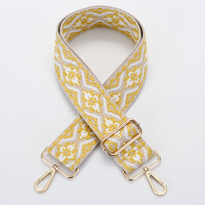 Yellow and white ethnic style patterned canvas bag strap with gold-toned adjustable buckle and swivel snap hooks.