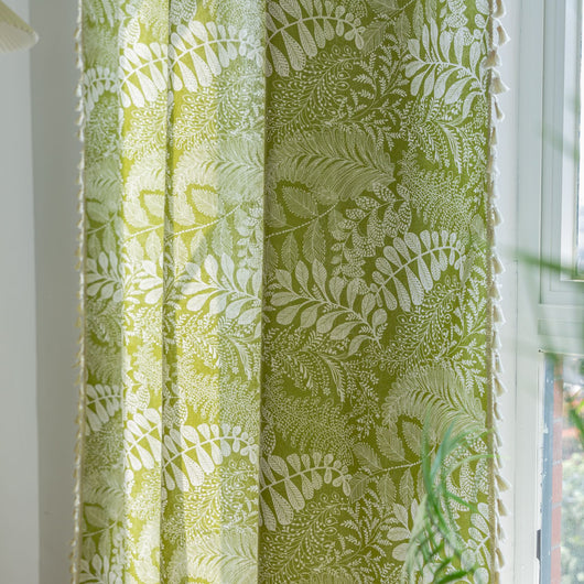 Green curtain with white leafy botanical pattern and cream tassels, hanging in a window with natural light. - Image 6