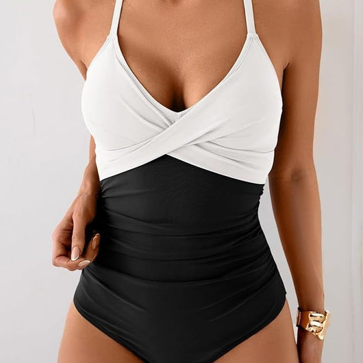 Women's black and white one-piece swimsuit with a twisted halter top and ruched detailing on the bottom.