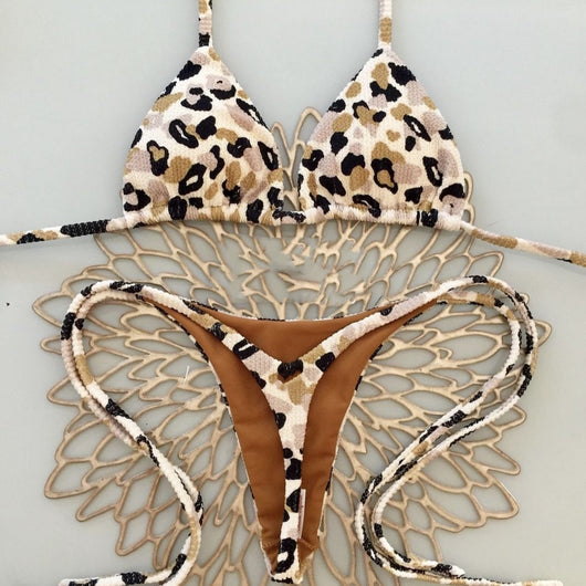 White textured bikini with red cherry print, featuring a triangle top and tie-side bottoms, on a woven mat. - Image 3