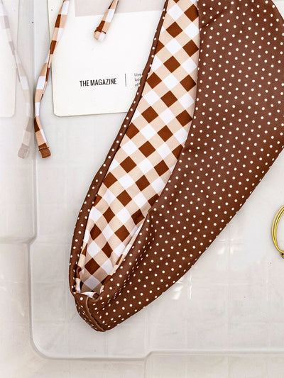 Retro brown and white plaid triangle bikini top with matching polka-dot bottoms, displayed flat with accessories. - Image 15
