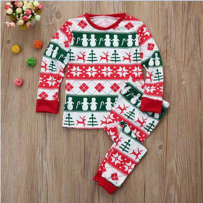 Family of four wearing matching red, green, and white Fair Isle Christmas pajamas, smiling together. - Image 2