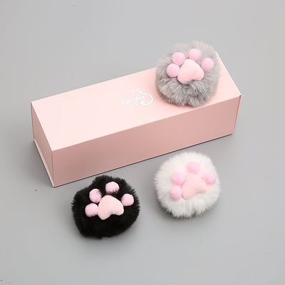 Three fluffy cat toy balls in white with pink paw print, gray, and black, next to a pink gift box. - Image 9