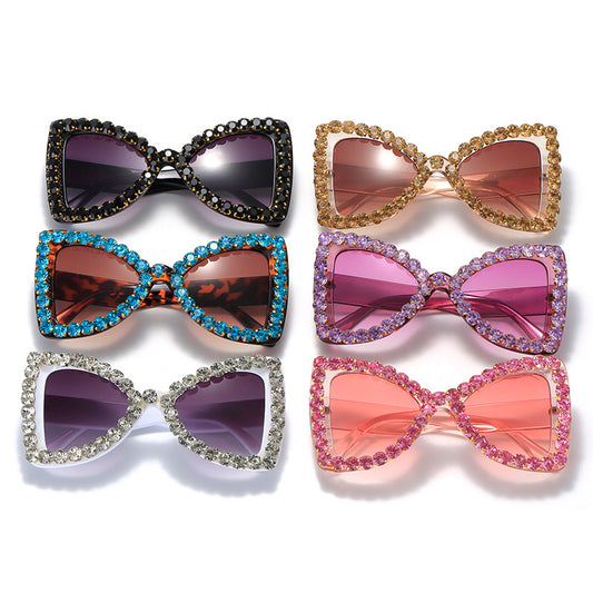 Pink butterfly frame sunglasses with purple gradient lenses and sparkling purple rhinestone embellishments.