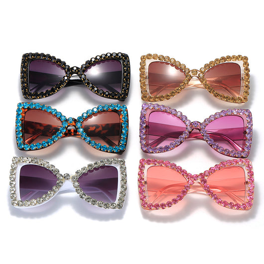 Pink butterfly frame sunglasses with purple gradient lenses and sparkling purple rhinestone embellishments.