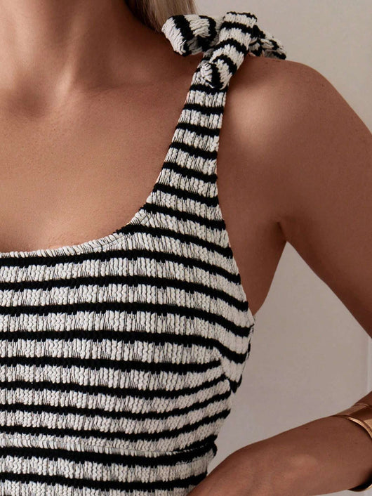 Women's black and white striped two-piece swimsuit with a tube top and high-waisted bottoms, worn by a person lounging on a white bed. - Image 8