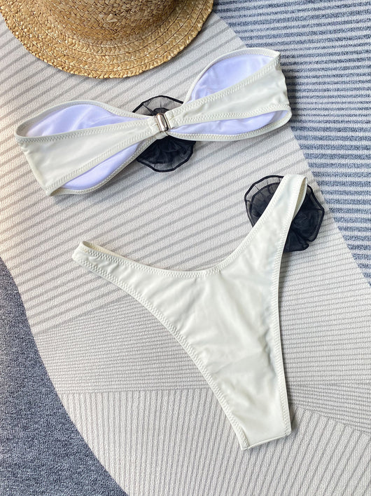 Black tube top bikini with white three-dimensional flower embellishments, worn by a woman partially submerged in water. - Image 23