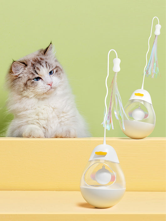 Yellow duck egg shaped tumbler cat toy with a clear middle, containing a yellow ball, and a flexible wand with purple and pink streamers. - Image 3