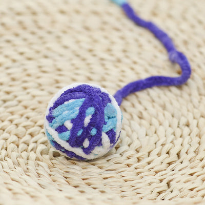 Colorful plush yarn ball cat toy in pink, blue, and white, with a long trailing strand, on a light background. - Image 42