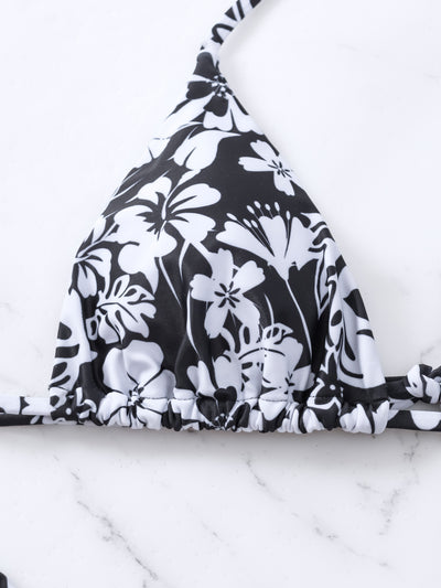 Woman wearing a black and white floral print triangle cup bikini swimsuit on a sunny beach. - Image 12