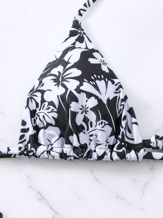 Woman wearing a black and white floral print triangle cup bikini swimsuit on a sunny beach. - Image 12