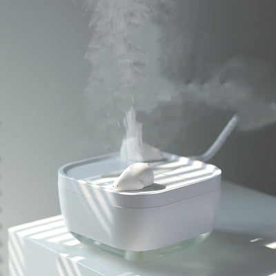 White ultrasonic humidifier with a clear base and a cute polar bear figurine on top, emitting a fine mist. - Image 6
