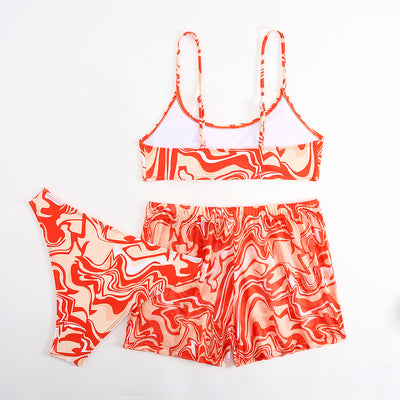 Red, orange, and white abstract swirl print three-piece bikini set with matching shorts, shown with a straw hat and sunglasses. - Image 15