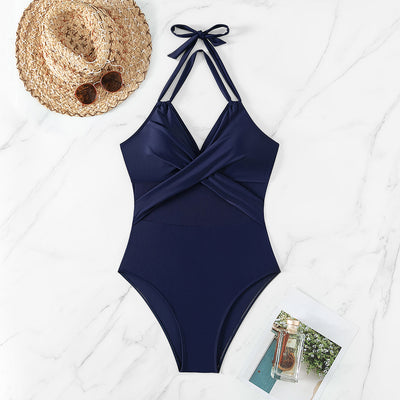 Woman in a green halter-neck one-piece swimsuit with cross-strap design and mesh cutouts, on a beach. - Image 18