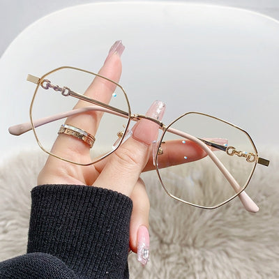 Rose gold frameless polygon anti-blue light glasses with clear lenses, held by a hand with pink nails. - Image 14