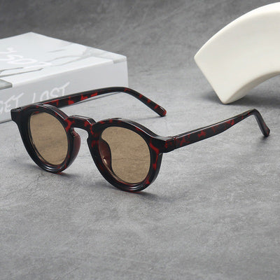 Vintage round frame sunglasses with black frames and pink lenses on a gray surface. - Image 19