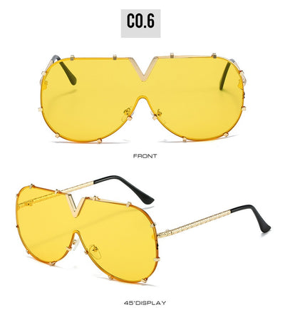 Oversized V-shaped sunglasses with a gold metal frame, white accents, clear lenses, and decorative rivets. - Image 25
