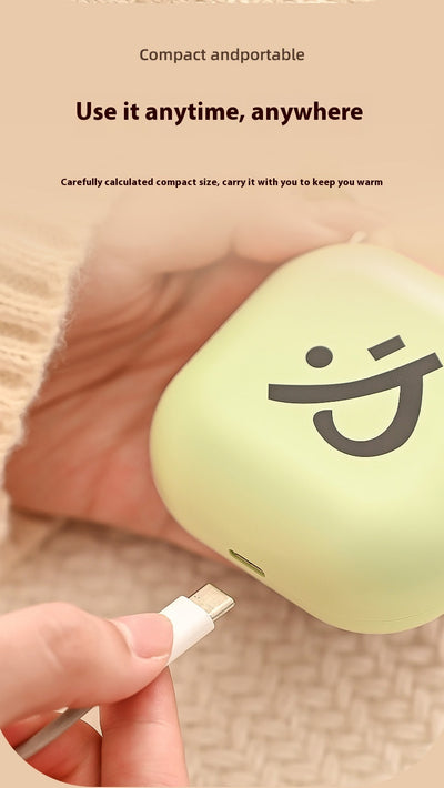 Light green square hand warmer with rounded corners and a black smiley face, hanging from a two-tone lanyard. - Image 13