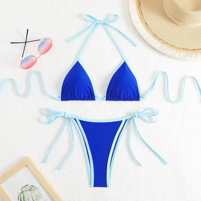 Royal blue two-piece bikini with light blue trim and tie straps, laid flat on a white textured surface. - Image 27