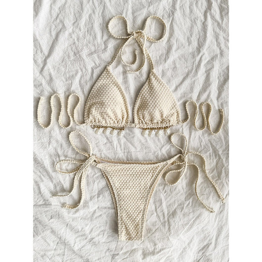 White halter lace-up bikini with a textured pattern, styled with a straw hat and gold jewelry on a sandy background. - Image 4
