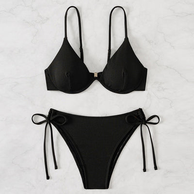 Black ribbed two-piece bikini with an underwire top and tie-side bottoms on a white marble surface. - Image 3