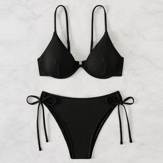 Black ribbed two-piece bikini with an underwire top and tie-side bottoms on a white marble surface. - Image 3
