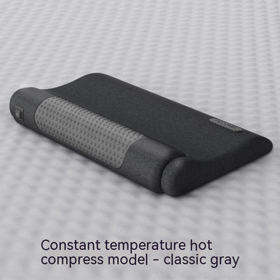 Dark gray cervical spine pillow with light gray textured massage area and power button on a light gray surface. - Image 5